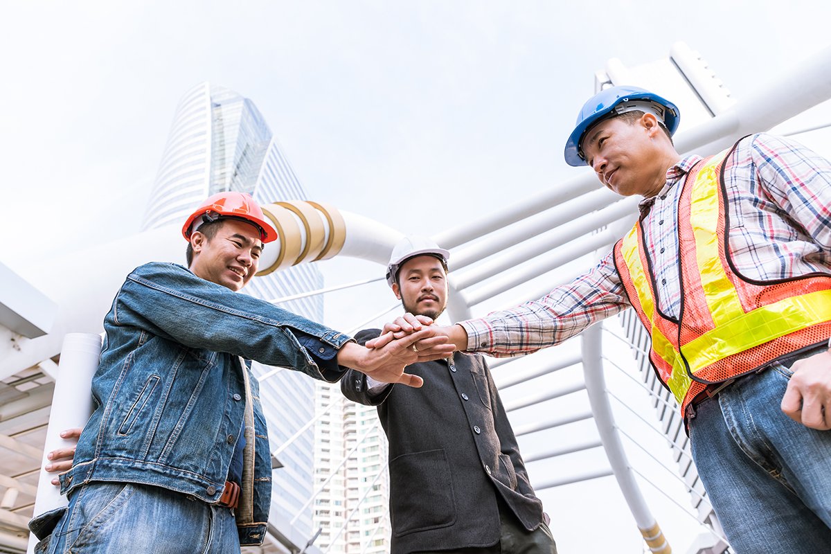 Manager meeting with engineer at outdoor site stack hand for tea